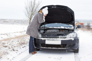 Lady troubleshooting her car in the snow